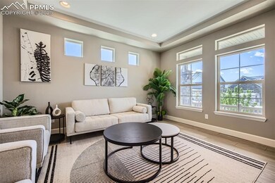 Sitting area, tray ceiling, recessed lighting, and light wood luxury vinyl finished floors