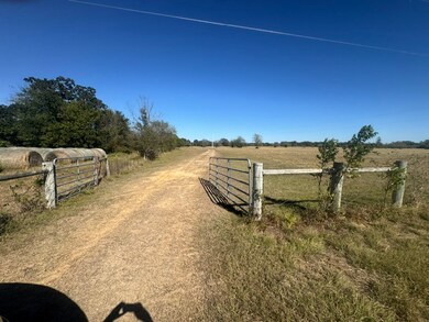 View of dirt / gravel road featuring a rural view and a gate