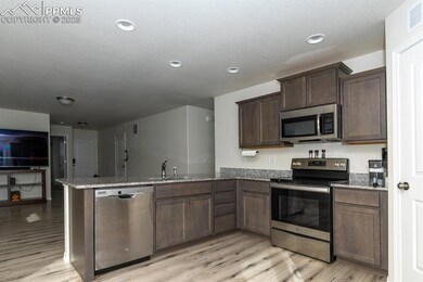 Kitchen with kitchen peninsula, sink, appliances w