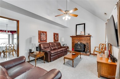 Living room with light carpet, ceiling fan, a wood
