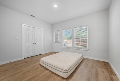 Bedroom with light wood finished floors, recessed lighting, and a closet