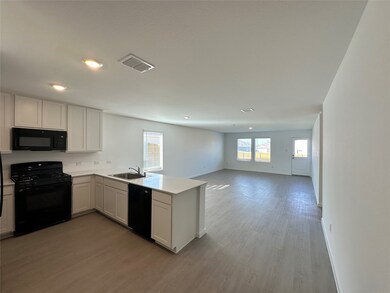 Kitchen with black appliances, a peninsula, dark wood finished floors, white cabinetry, and open floor plan