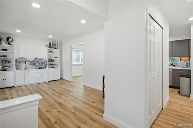 Bar area with light countertops, recessed lighting, light wood-type flooring, ornamental molding, and open shelves