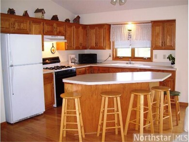 Kitchen is vaulted, has hardwood flooring, feature