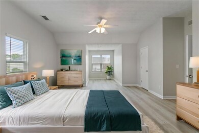 Bedroom featuring lofted ceiling, light wood-style floors, baseboards, and ceiling fan