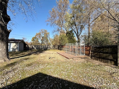 Fenced backyard featuring an outbuilding