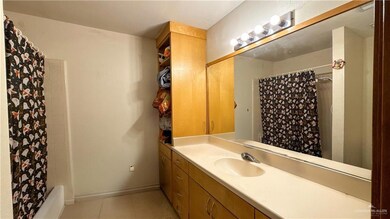 Full bathroom with tile patterned floors, shower / bath combo, baseboards, and vanity