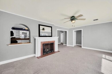 Living room featuring a fireplace, ceiling fan, li