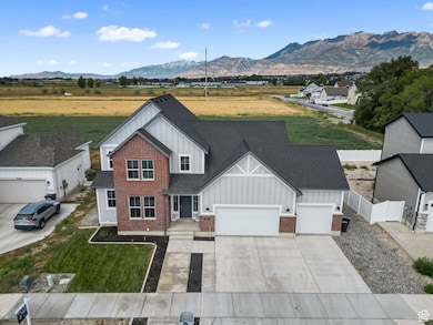 View of front of property featuring board and batten siding, driveway, an attached garage, and a mountain view