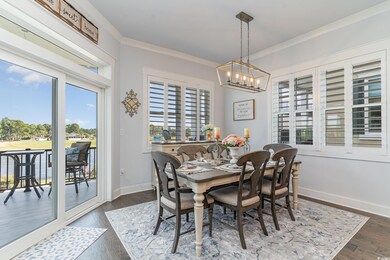 Dining area featuring a notable chandelier, dark h