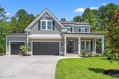 View of front of house featuring board and batten siding, a porch, a front lawn, concrete driveway, and an attached garage