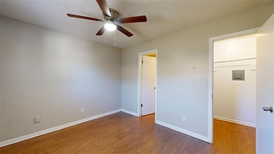 Unfurnished bedroom with wood finished floors and a ceiling fan