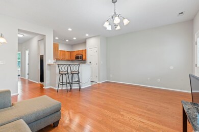 Living room with a chandelier, light wood-type flooring, baseboards, and recessed lighting