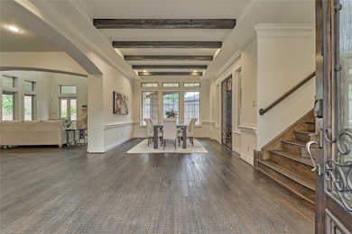 Entry view of formal dining, beautiful wood staircase and a sneak peek into the den