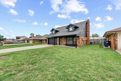 View of front of house featuring a chimney, driveway, brick siding, and a shingled roof