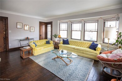 Living room featuring dark hardwood / wood-style flooring, crown molding, and a healthy amount of sunlight