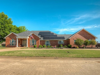 Single story home with solar panels, a front yard, brick siding, concrete driveway, and a shingled roof