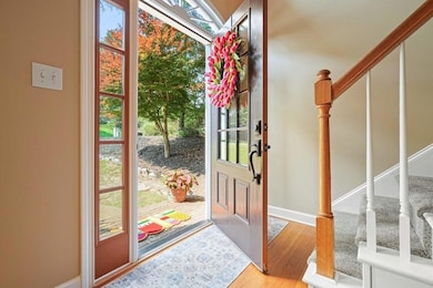 Entrance foyer with stairs, wood finished floors, and baseboards