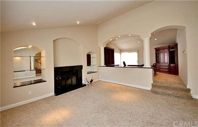 Spacious formal living room with a fireplace, arch