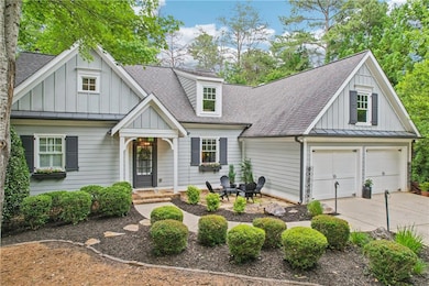 View of front of property with a shingled roof, driveway, board and batten siding, and a standing seam roof