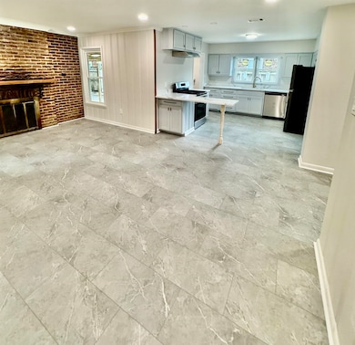 Unfurnished living room with a brick fireplace and recessed lighting