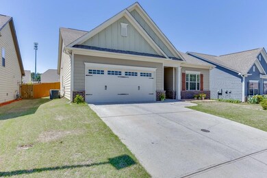 View of front of house featuring board and batten siding, brick siding, an attached garage, concrete driveway, and a shingled roof