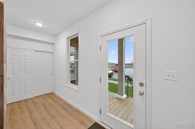 Doorway featuring baseboards and wood finished floors