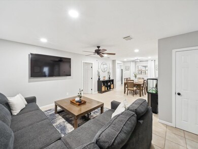 Living room featuring ceiling fan and light tile p