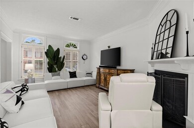 Living room with ornamental molding, wood finished floors, and a fireplace