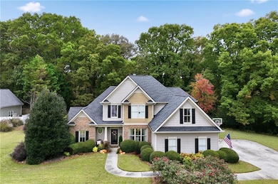 View of front of house featuring a front yard and roof with shingles
