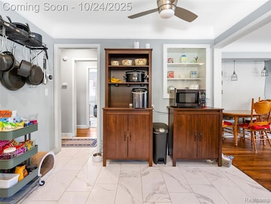 Kitchen featuring light marble finish floors, stainless steel microwave, and a ceiling fan