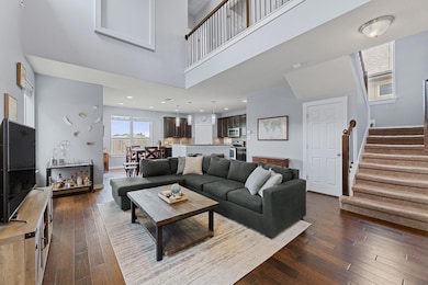 Living area featuring a towering ceiling, stairs,