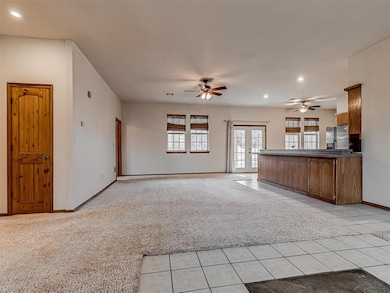 Unfurnished living room with light carpet, french doors, and ceiling fan