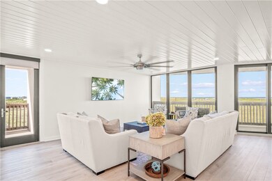 The living room has floor to ceiling windows and a