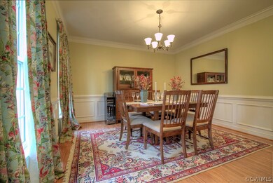 Dining room with chandelier, chair rail, wainscoting and double member crown molding.