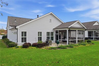 Rear view of house featuring a sunroom, a shingled roof, a yard, and a patio
