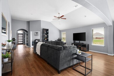 Living area featuring arched walkways, ceiling fa