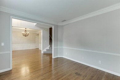 Unfurnished room with a chandelier, crown molding, wood finished floors, stairs, and a wainscoted wall