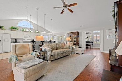 Living area with high vaulted ceiling, light wood-