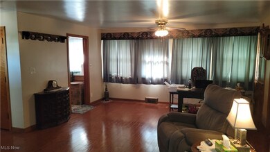 Living room with healthy amount of natural light, wood finished floors, and a ceiling fan
