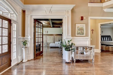 Foyer with coffered ceiling, ornate columns, beame
