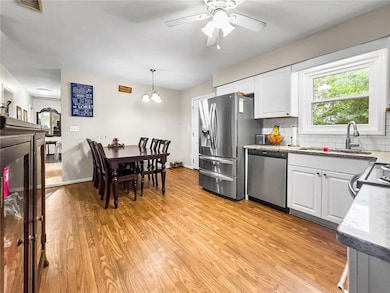 Kitchen with white cabinets, light wood-style floo