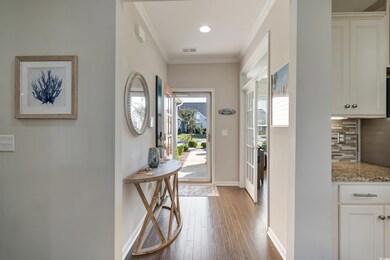 Entryway featuring crown molding and wood-type flo