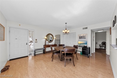 Dining area featuring a chandelier, baseboards, visible vents, and light wood finished floors