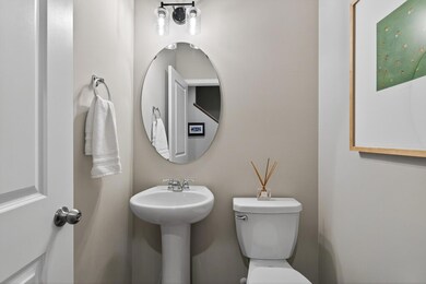 Sleek and stylish, this powder room showcases contemporary touches like the large round mirror and updated light fixture.