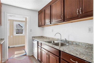 Kitchen with light hardwood / wood-style flooring, a textured ceiling, light stone countertops, sink, and stainless steel dishwasher