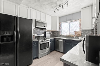 Kitchen with stainless steel appliances, white cab