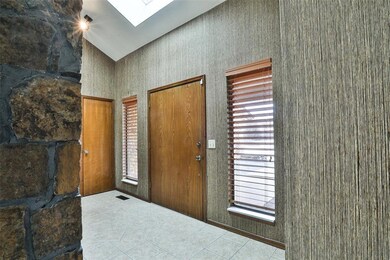 Tiled foyer with a skylight and high vaulted ceili
