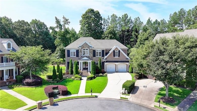 Colonial-style house featuring concrete driveway, a front lawn, and an attached garage
