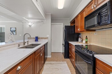 Kitchen featuring black appliances, tasteful back